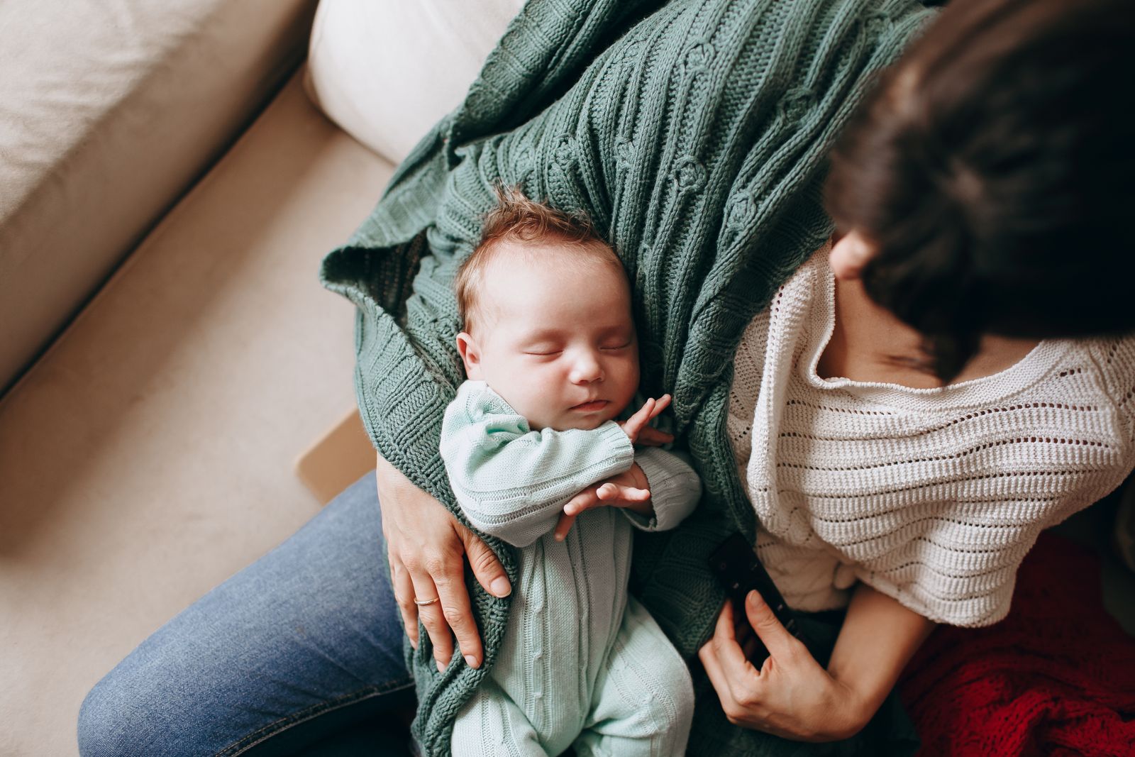 A mother gently holding her sleeping newborn, capturing a tender moment of love and warmth