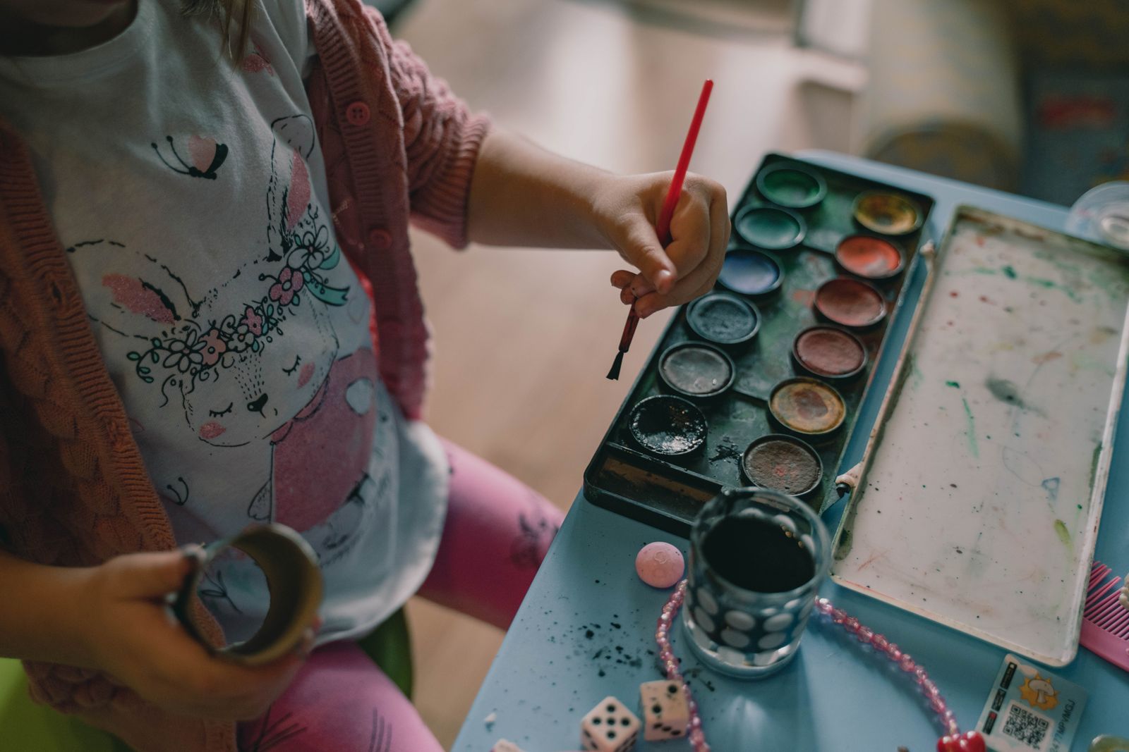 A child painting with watercolors at a table
