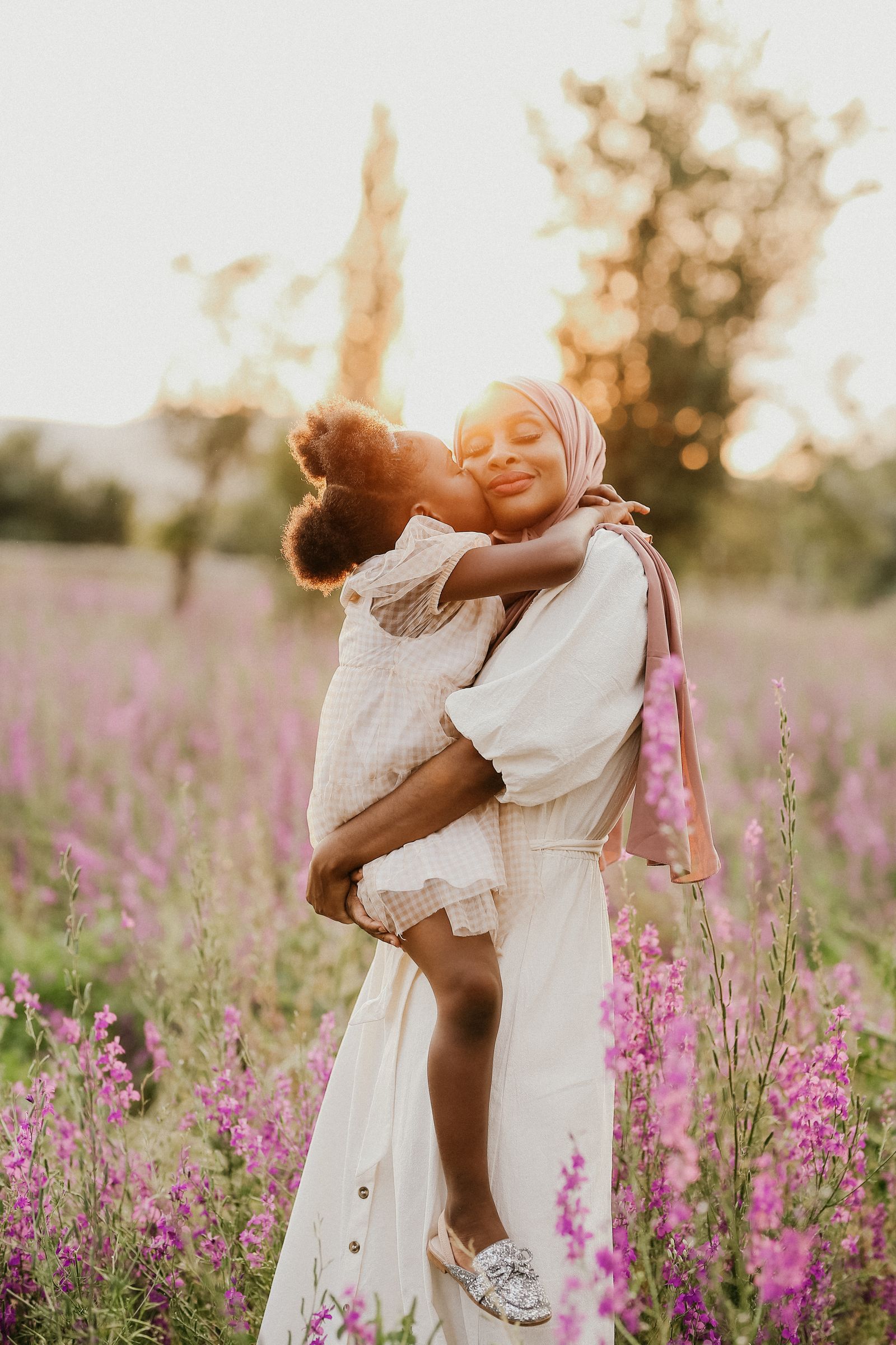 A mother holding and comforting her daughter outdoors
